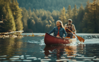 middle-age couple canoeing on a lake with a forest in the background on a sunny day